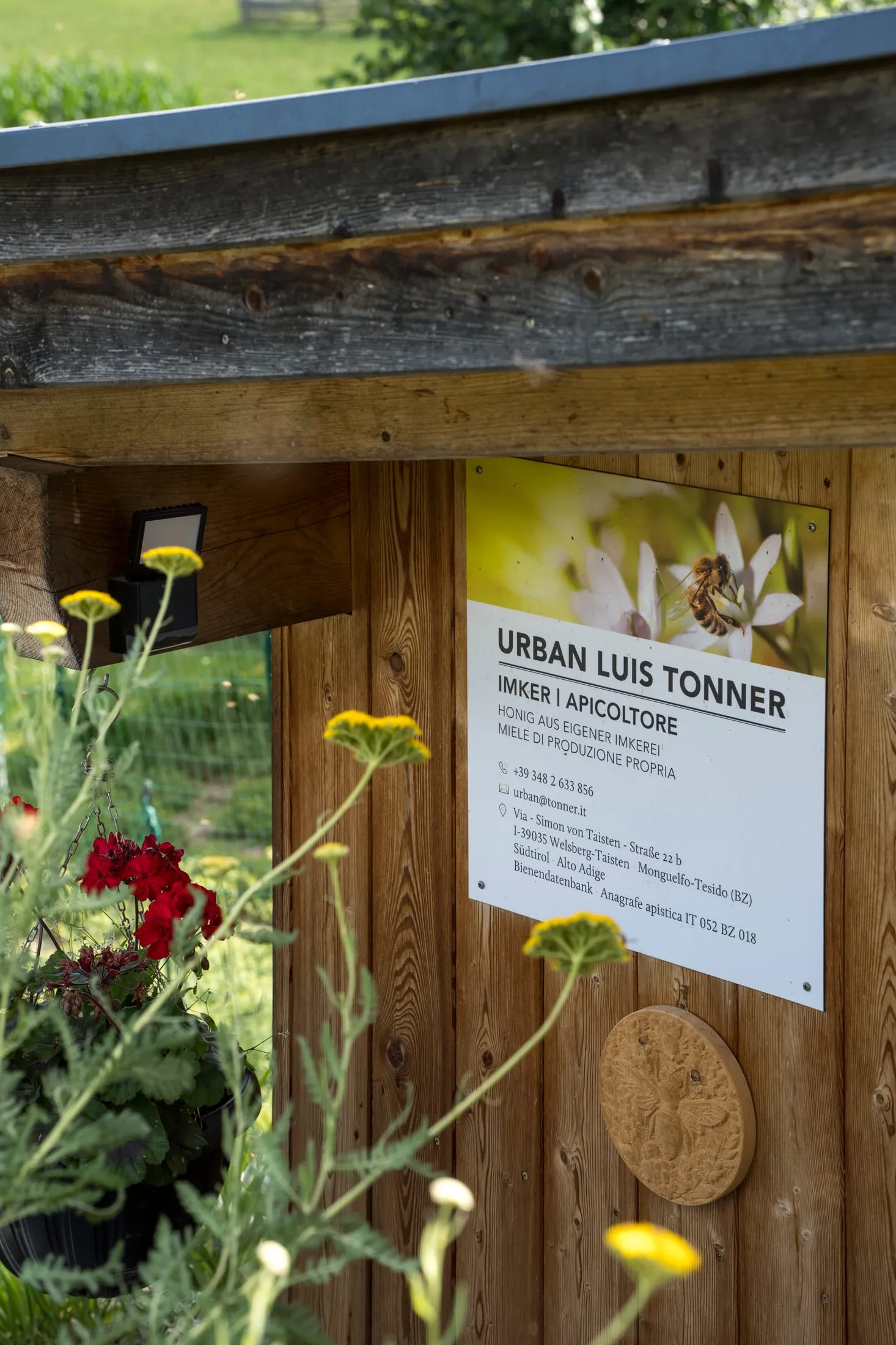 Schild am Bienenhaus: Urban Luis Tonner, Imker | Apicoltore, mit Adresse und Telefonnummer